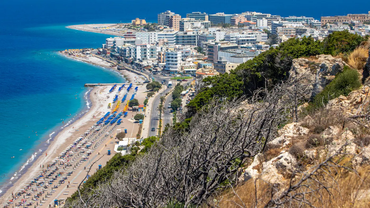Scenic aerial view of a vibrant beachfront city in Rhodes, Greece, highlighting the summer coastline.