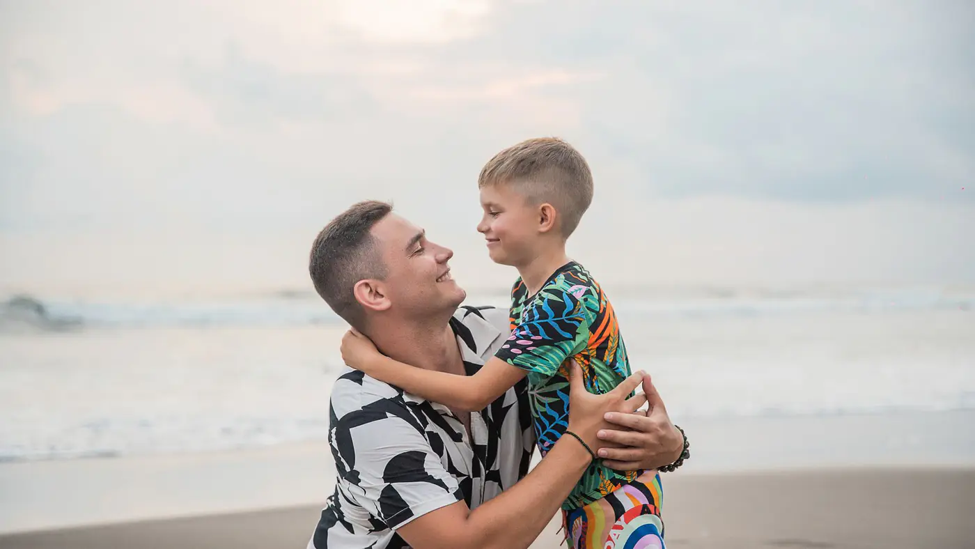 Heartwarming moment of a father and son bonding at the beach, showcasing love and connection.