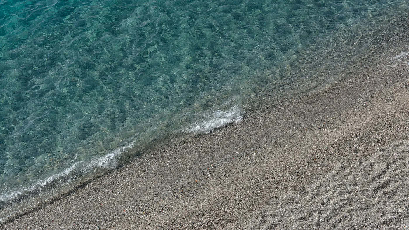 A serene beach scene with gentle waves meeting the sandy shore, perfect for relaxation themes.