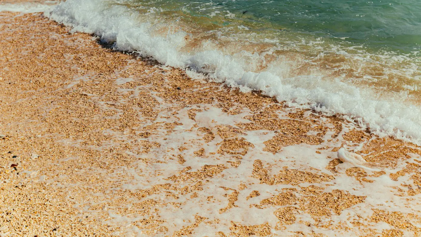 A serene image of waves gently splashing onto a sandy beach, capturing the essence of nature.